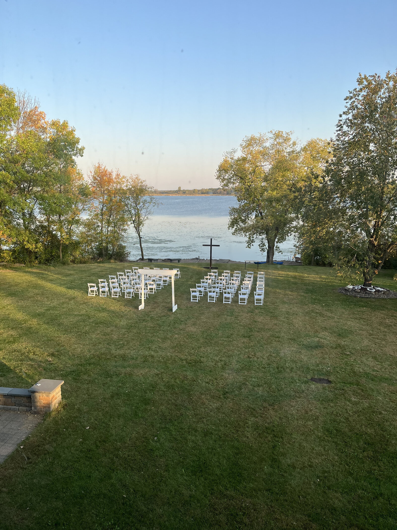 Ceremony seating facing the lake, arbor dressed in sunflowers and greenery