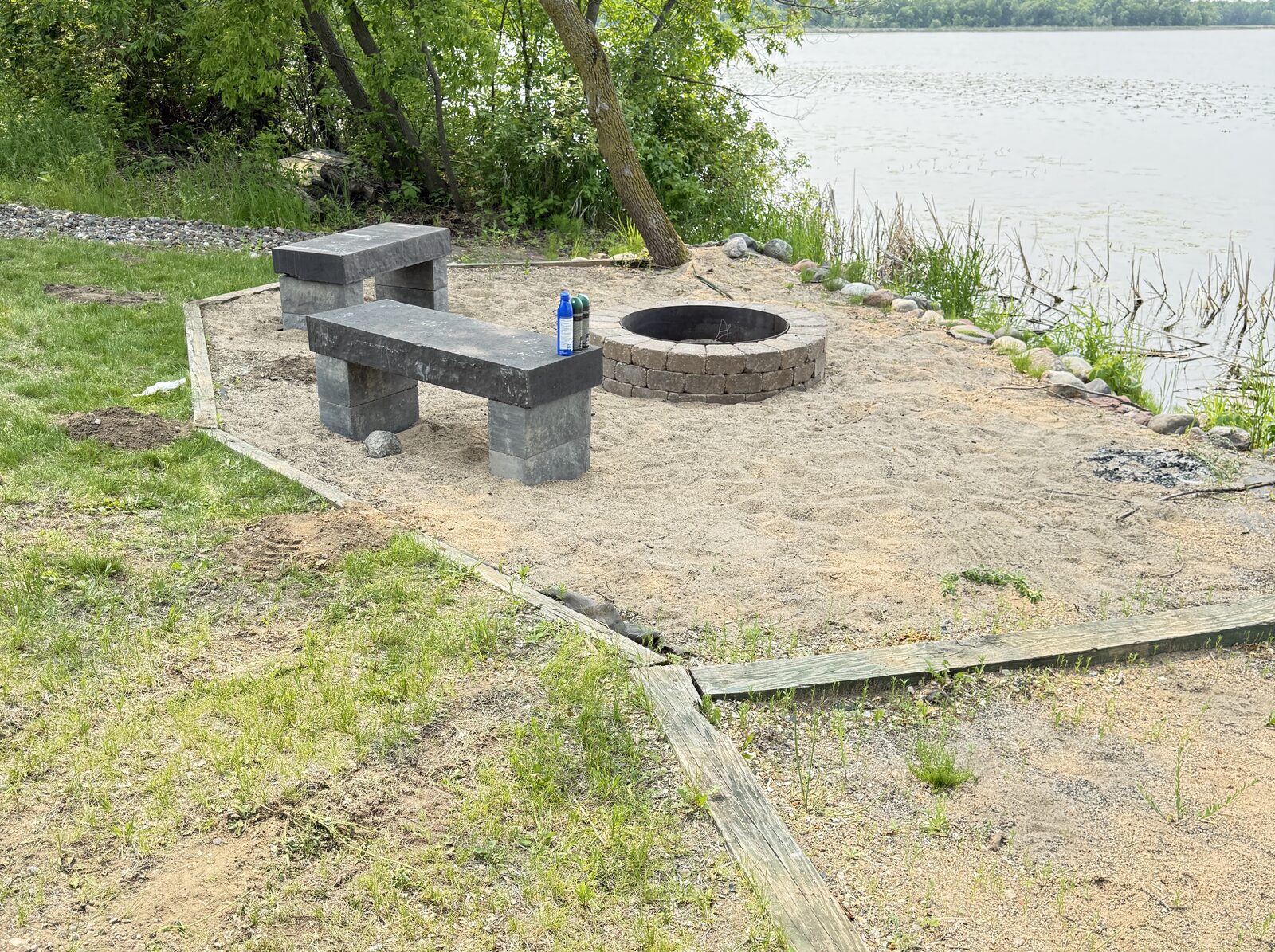 Stone firepit and benches at the water's edge